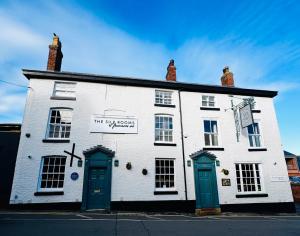 a white building with blue doors on a street at The Silk Rooms, at The Freemasons Inn in Knutsford