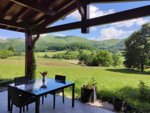 a table on a patio with a view of mountains at Eki-begia in Ainhice-Mongelos