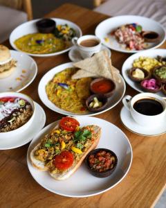 a table topped with plates of food and cups of coffee at Nadi Nature Resort - Adults Only in Tabanan +52 photos