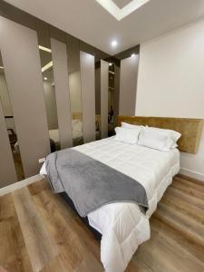 a bedroom with a large bed with white sheets at Bello Departamento in Mexicali