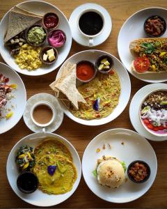 a table with many plates of food on it at Nadi Nature Resort - Adults Only in Tabanan