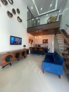 a living room with a blue couch and a staircase at Bello Departamento in Mexicali