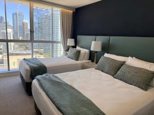 a hotel room with two beds and a large window at Golden Sands on the Beach - Absolute Beachfront Apartments in Gold Coast +133 photos