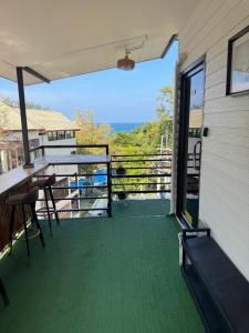 a balcony with a table and chairs and a view at Primmy house kohtao in Ko Tao