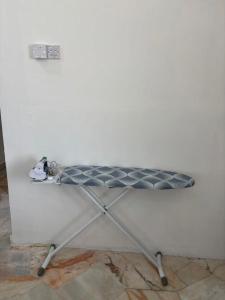 a ping pong table against a white wall at KH Homestay in Kampong Batu Lapan