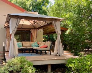 a gazebo with a couch and chairs on a deck at Riverfront with EV charger - Sequoia River Cottage in Three Rivers