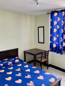 a bedroom with a bed and a table and a curtain at PG Vacation Rental in Lapu Lapu City