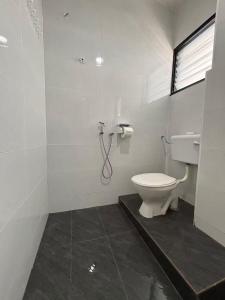 a bathroom with a toilet and a shower at KH Homestay in Kampong Batu Lapan +6 photos