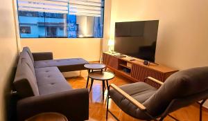 a living room with a couch and a flat screen tv at Aruma Andina Hotel CHAVÍN in Chavín de Huantar