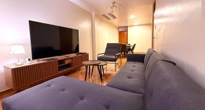 a living room with a couch and a flat screen tv at Aruma Andina Hotel CHAVÍN in Chavín de Huantar
