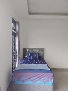 a bedroom with a bed in a white room at Mroom Villa Cipanas in Pacet