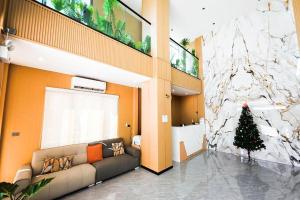 a living room with a couch and a christmas tree at VELIN Pattaya Hotel in Pattaya