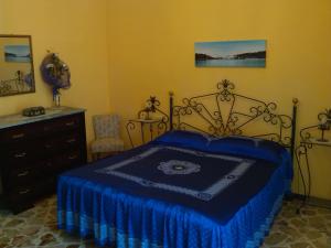 um quarto com uma cama azul e uma cómoda em Happy House Wifi Free Bici Free em Avola