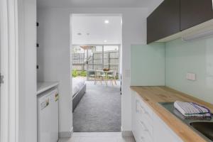 a kitchen with white cabinets and a view of a table at Bay View Sunrise in Lorne
