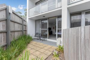 a house with glass doors and a patio at Bay View Sunrise in Lorne