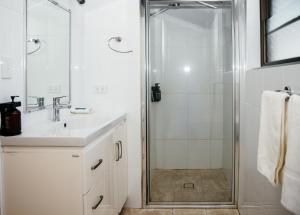 a white bathroom with a shower and a sink at All Travellers Motor Inn in Coonabarabran +27 photos