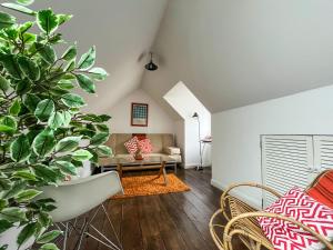 a living room with a couch and some plants at Sea-Scape in Penrhyn Bay