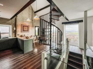 an open kitchen and dining room with a spiral staircase in a house at Sea-Scape in Penrhyn Bay