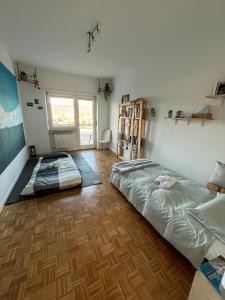 two beds in a room with wooden floors at Spazioso appartamento, ampio parcheggio, vicino Valle d'Aosta in Banchette