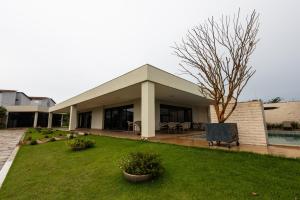 a house with a green yard with a pool at Espaço JF in Aparecida de Goiânia