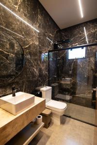 a bathroom with a toilet and a shower and a sink at Espaço JF in Aparecida de Goiânia