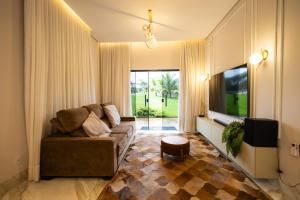 a living room with a couch and a tv at Espaço JF in Aparecida de Goiânia