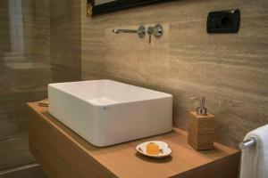 a white sink on a wooden counter in a bathroom at Alagona House in Syracuse