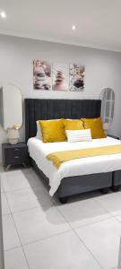 a bedroom with a large bed with yellow pillows at The Haven in Nelspruit