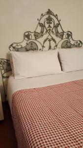 a bed with a red and white checkered blanket at Casa Belfiore Da Andrea in Ferrara