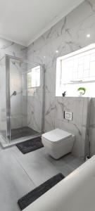 a white bathroom with a shower and a toilet at The Haven in Nelspruit +30 photos