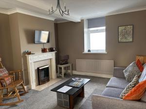 a living room with a couch and a fireplace at Greenmantle in Skinburness