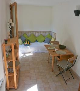 uma sala de estar com uma cama, uma mesa e cadeiras em La Petite Maison em Villeneuve-lès-Avignon