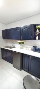 a kitchen with blue cabinets and a sink at The Haven in Nelspruit