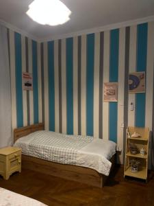 a bedroom with a bed and a striped wall at Green Rooms in Batumi +31 photos