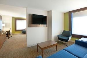 a living room filled with furniture and a tv at Holiday Inn Express Hotel & Suites Austin Downtown, an IHG Hotel in Austin