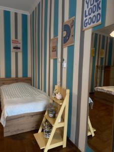 a bedroom with a bed and a shelf with a ladder at Green Rooms in Batumi