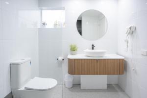 a bathroom with a sink and a toilet and a mirror at Bay View Alfresco in Lorne +16 photos