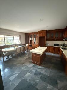 a kitchen with wooden cabinets and a table in it at 5BR Private Pool in Jomtien Beach