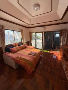 a bedroom with a large bed and windows at 5BR Private Pool in Jomtien Beach