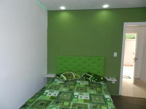 Dormitorio verde con cama con pared verde en Magias da Serra en Canela