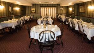 un comedor con mesas y sillas con mesas blancas en The Globe Inn, en East Greenville