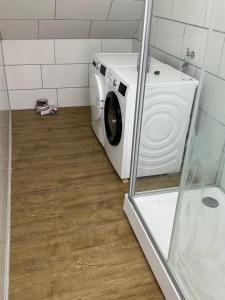 a washer and dryer in a bathroom with a shower at Schelder Unterkunft in Dillenburg