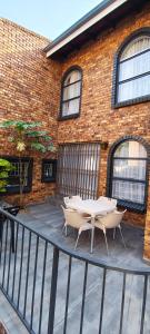 a patio with two tables and chairs in front of a brick building at The Haven in Nelspruit