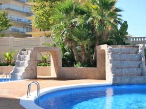 a swimming pool with a fountain and palm trees at Turquesa Beach Unitursa in Calpe