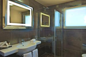 a bathroom with a sink and a glass shower at Zen Hotel Versilia in Marina di Pietrasanta