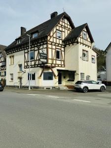 a white car parked in front of a building at Schelder Unterkunft in Dillenburg