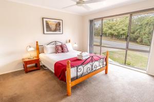 a bedroom with a bed and a large window at Hargreaves House in Bright