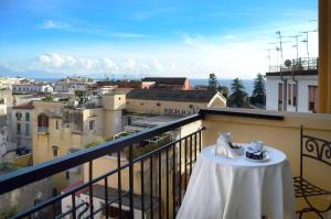 a table on a balcony with a view of a city at Pinto-Storey Hotel in Naples