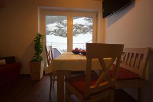 a dining room with a table and a window with snow at Alpenapart Saphir in Sölden