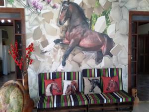un mural de un caballo en una pared junto a un sofá en Chacara Santa Barbara, en Manaus